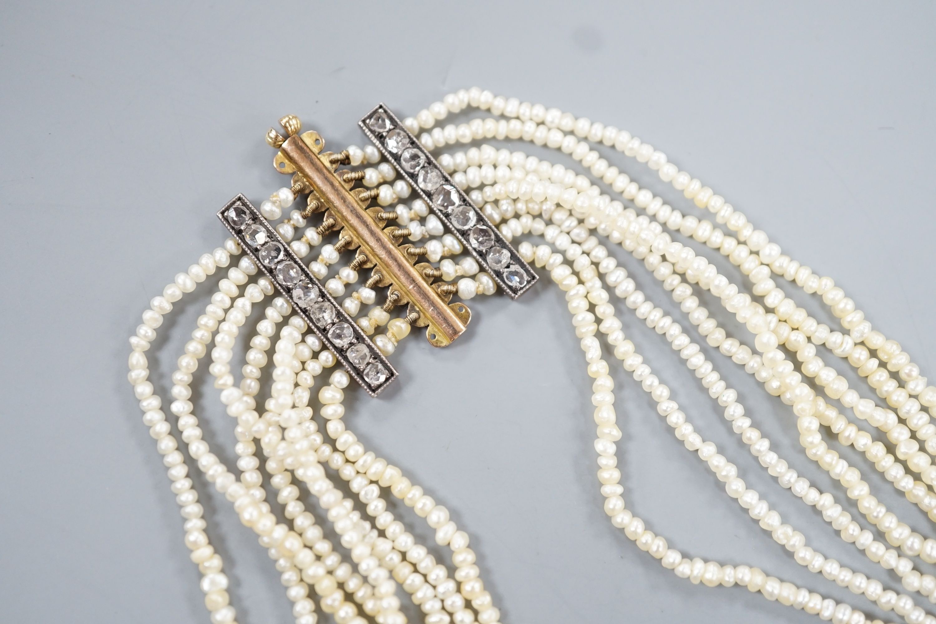 A 19th century multi-strand seed pearl choker necklace with yellow metal and rose cut diamond set clasp and trellis motif, approx. 40cm, gross weight 31.1 grams.